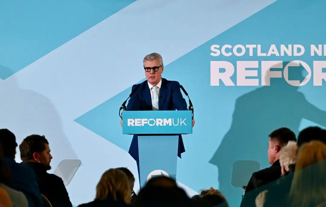 Malcolm Offord standing at a podium for a press confernece