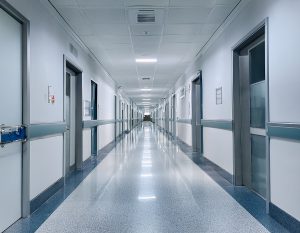 An empty NHS corridor stretching into the distance looking cold and sterile and absent of activity