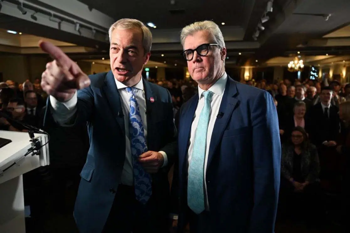 Nigel Farage pointing as he stands next to Malcolm Offord