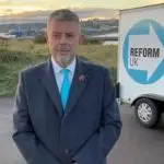 reform candidate standing next to a reform trailer box