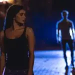 A lone female walking a dark street being followed by a male